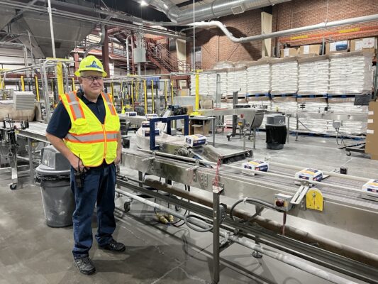 factory worker, steven Pendrod, stands in the middle of a Amalgamated Sugar Company factory where sugar is being packaged