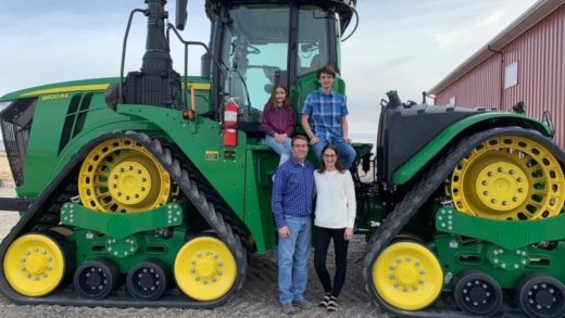 Entire family in front of tractor.